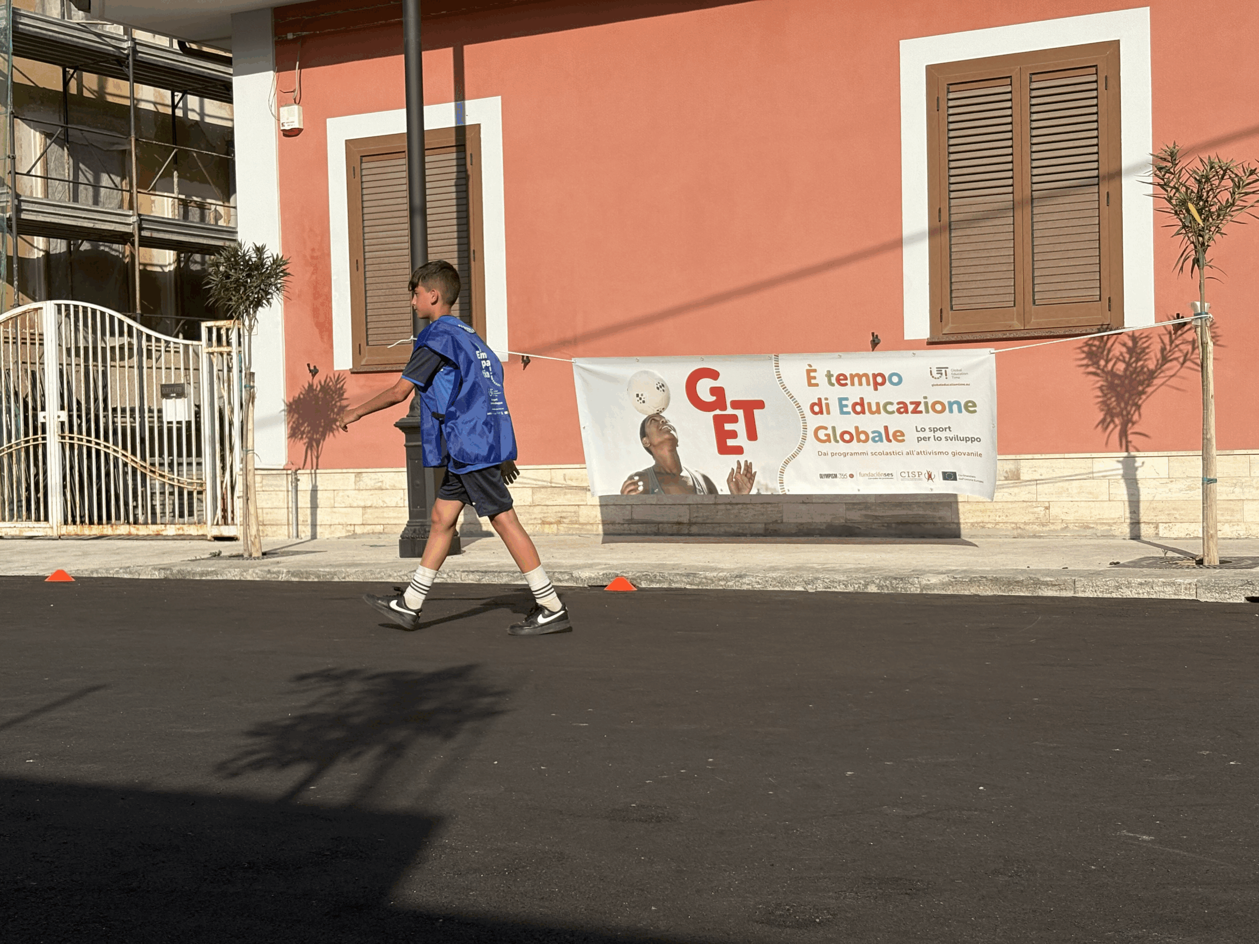 ragazzo cammina davanti al banner del progetto GET