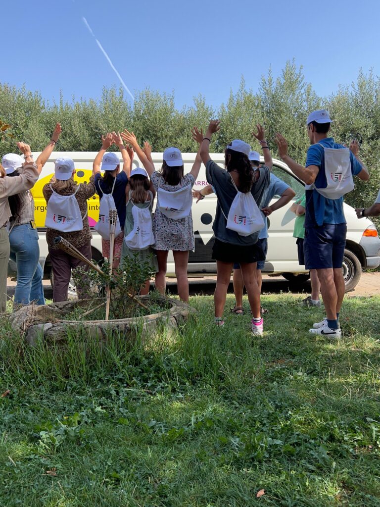 Young participants to the GET summer camp raise their hands together to celebrate.